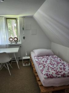 a bedroom with a bed and a desk and a window at Gemütliche Ferienwohnung in Bad Fallingbostel