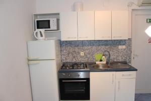 a kitchen with a stove and a refrigerator at Vidoni - apartmani Roza in Zastražišće +14 photos