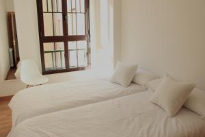 a white bed in a room with a window at Apartaments Plaza Príncipe Viana in Pamplona