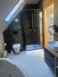 a bathroom with a tub and a toilet and a sink at Domek za rzeką in Zawoja +5 photos