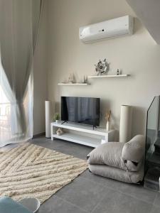 赫尔格达Cozy 2BR Seaview loft in Mesca Somabay的客厅配有平面电视和1张床。