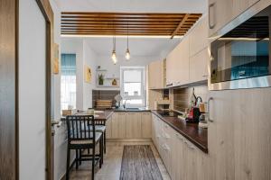a kitchen with wooden cabinets and a table and chairs at Wooden Touch Studio in Braşov