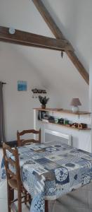 a dining room table with a blue and white quilt on it at La grange du Manemeur in Quiberon +2 photos