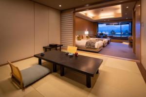 a bedroom with a bed and a table and a couch at Miyajima Grand Hotel Arimoto in Miyajima +37 photos