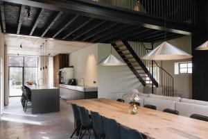 a dining room and kitchen with a wooden table and chairs at Schuur 80 in Haasdonk