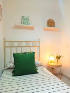- une chambre avec un oreiller vert sur un lit dans l'établissement Casa La Muralla - Alojamiento con vistas a las montañas, à San Andrés