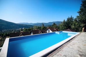 a large swimming pool with a mountain in the background at Rubus resort in Yaremche