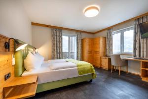 a hotel room with a bed and a desk and window at Hotel Hubertus in Sankt Johann im Pongau +86 photos