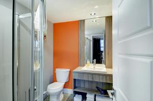 an orange bathroom with a toilet and a sink at L'Express in Saint-Férréol-les-Neiges +32 photos