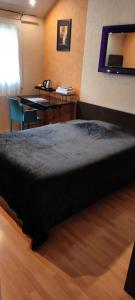 Un dormitorio con una cama, un escritorio y una mesa. en Chambre Grand lit Afrik, en Combs-la-Ville