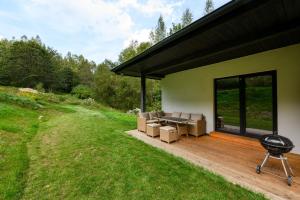 a patio with a couch and chairs on a wooden deck at Chata Henry in Krásná
