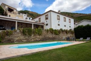 a villa with a swimming pool in front of a house at Casa grande Covelinhas in Covelinhas