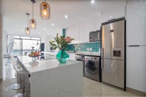 a kitchen with a refrigerator and a vase of flowers on a counter at Simla Luxury Apartments 11 in Margate