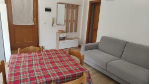 a living room with a couch and a table at casa LUCIANER in Molveno