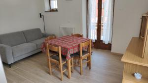 a living room with a table and a couch at casa LUCIANER in Molveno