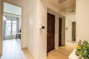 a hallway with a door and a table with a plant at Intero alloggio - Torino Aurora in Turin +7 photos