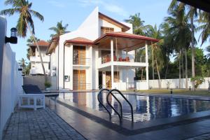 a house with a swimming pool in front of it at Bluewater Beach Resort in Trincomalee