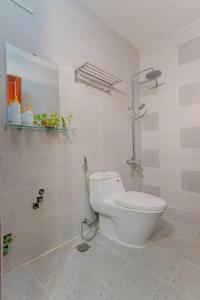 a white bathroom with a toilet and a shower at Rio 02 homestay in Vung Tau