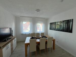 a dining room with a table and chairs and a television at Stadtwohnung Trossingen Zentrum 5 Zimmer Maisonette in Trossingen +30 photos