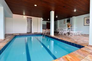 a swimming pool in a house with a table and chairs at Mirante Hotel in Ouro Preto