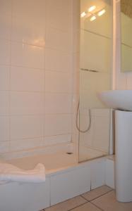 a white bath tub sitting next to a white toilet at Hotel Concorde in Nîmes