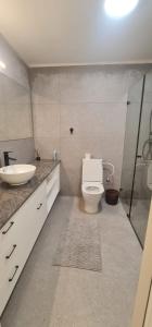 a bathroom with a toilet and a sink and a shower at המטרופולו in Caesarea