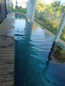 a pool of water in front of a house at המטרופולו in Caesarea +1 photo