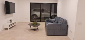a living room with a couch and a table and a car at המטרופולו in Caesarea