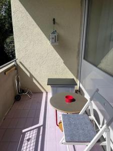 a small table and a chair on a balcony at Moderne 1-Zimmer Wohnung stadtnah in Neu Ulm