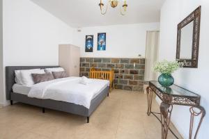 Un dormitorio con una cama, una mesa y un espejo. en צימר בין ההרים - צימרים כפריים קסומים עם בריכה, ג'קוזי ונוף מהמם, en ‘Ein el Asad 23 fotos más