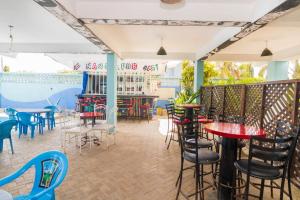 a restaurant with tables and chairs and a bar at Pidows studio apartment in Shanzu