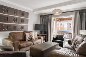 una sala de estar con un sofá y una silla en Avemore Jan Cats No 5 full backup power, en Stellenbosch