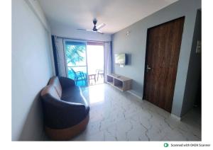 a living room with a couch and a sliding door at Panorama Seascape in Harnai