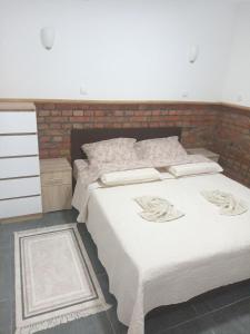 a bedroom with two beds and a brick wall at Kućica za odmor Treće nebo in TrÅ¡iÄ‡