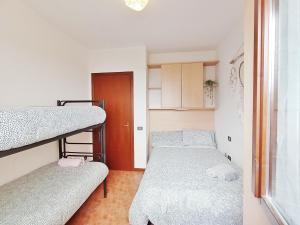a dorm room with two bunk beds and a door at Le Casine di Tuscany Maremma Saturnia in Catabbio