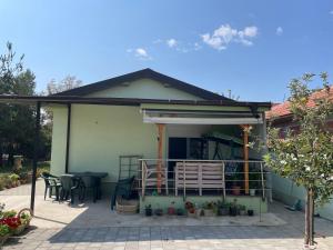 una casa con un patio con mesa y sillas en The Little Green House, en Petrovec 5 fotos más