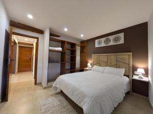 a bedroom with a large white bed and two lamps at CA LA PAULA in Rocafort de Vallbona