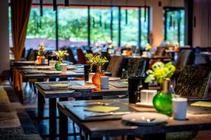 a dining room with tables and chairs with flowers on them at Friendly Cityhotel Oktopus in Siegburg