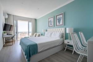 una camera da letto con un letto, una scrivania e una televisione di Sea Lovers - Sea front - studio apartment a Monte Gordo