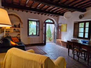 a living room with a couch and a table at MIMOSA at Pietraie a nice studio with terrace on the Valley in Montecastelli Pisano