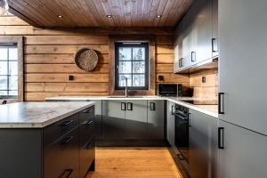 イドレにあるBrunbjörnen Lodge med bastu och utsikt i Idreの木製の壁と木製の天井のキッチン +36枚の写真