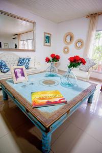 a living room with a table with flowers on it at Casa Nora Alojamiento Entero, 4 Habitaciones Capacidad Máxima 9 huéspedes in Ríohacha