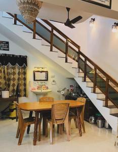 a dining room with a table and a staircase at Cape-Cottage in Nāgercoil
