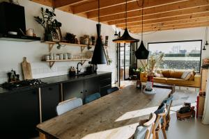a kitchen and dining room with a wooden table at Familie Buitenhuys Countryside Home with wide landscape views from the bathtub in Oosterleek