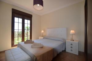 ein weißes Schlafzimmer mit einem Bett und einem Fenster in der Unterkunft Las Palmeras SOLMARES in Isla del Moral + 89 Fotos