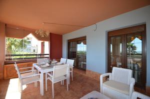 ein Esszimmer mit Tisch und Stühlen und Fenstern in der Unterkunft Las Palmeras SOLMARES in Isla del Moral