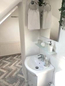a white bathroom with a sink and a mirror at Ferienwohnung Fischpforte in Hameln +17 photos