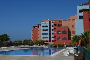 ein Pool vor einigen Gebäuden in der Unterkunft Las Palmeras SOLMARES in Isla del Moral