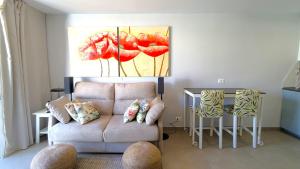 un soggiorno con un divano e un tavolo di Pool level flat in Parque Santiago 1 a Playa de las Americas