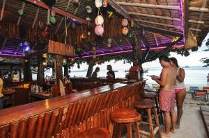 a couple of people standing at a bar at Phi Phi Relax Beach Resort in Phi Phi Islands